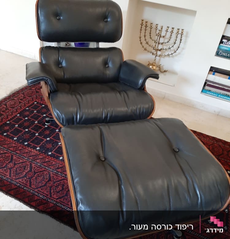 כורסה מרופדת בעור שחור עם כפתורים